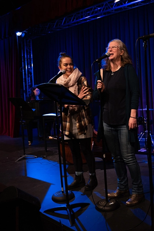 two-women-on-stage-singing