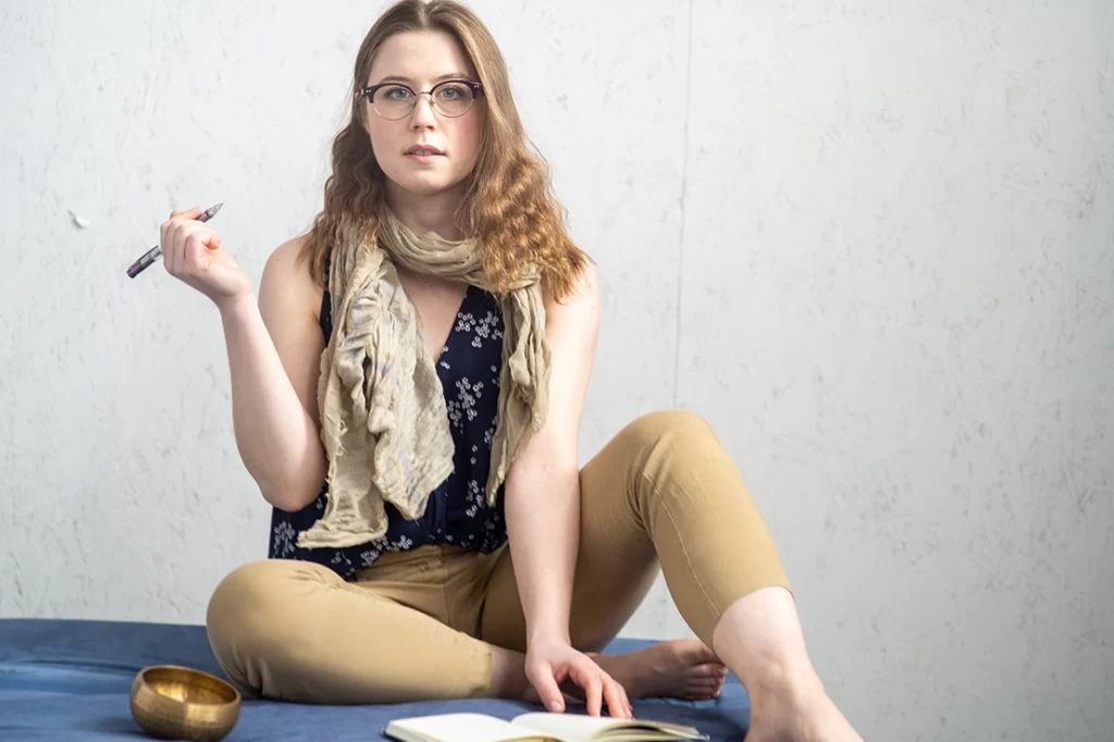 woman-wearing-glasses-posing-with-journal-and-pen