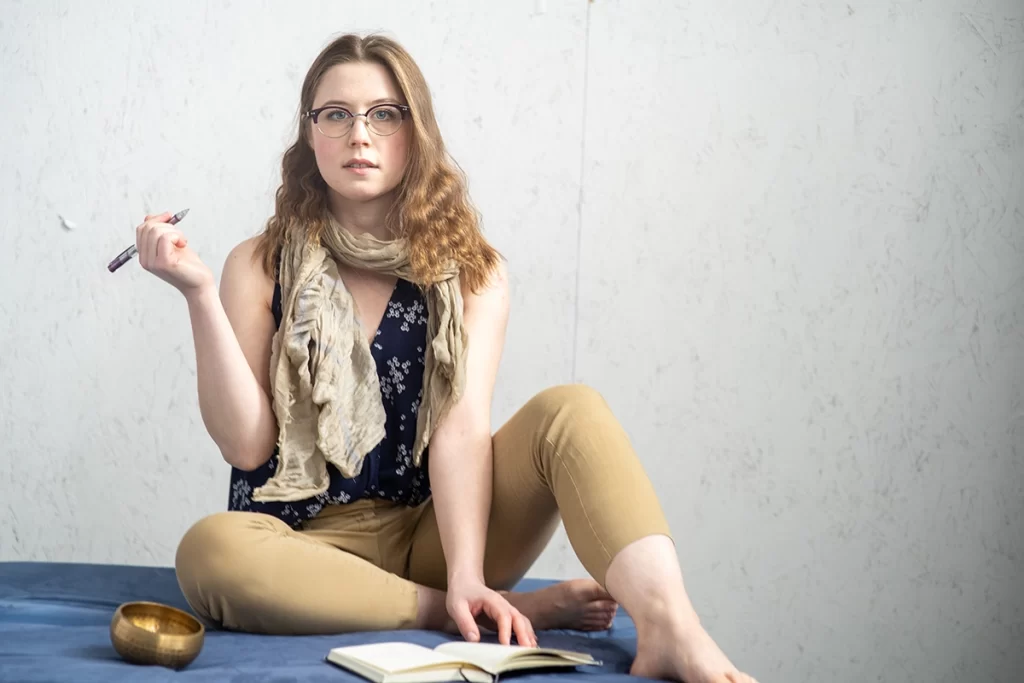 woman-wearing-glasses-posing-with-pencil-in-hand-above-journal